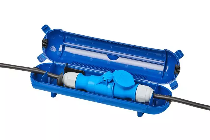 Offenes blaues Kunststoffgehäuse mit zwei schwarzen Kabeln, einem blauen Verbindungsstück im Inneren und weißen Kabelmanschetten