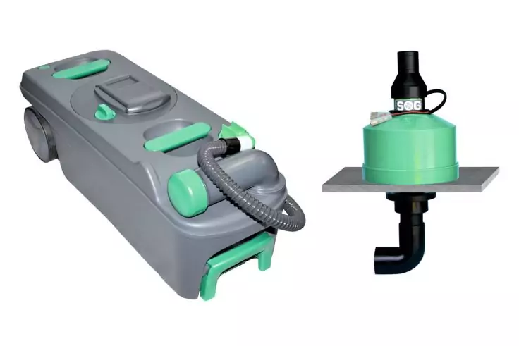 Grau-grünes rechteckiges Gerät auf Rädern mit Handgriff und flexiblem Schlauch; daneben ein grüner runder Behälter auf einer grauen Platte mit schwarzem Rohr