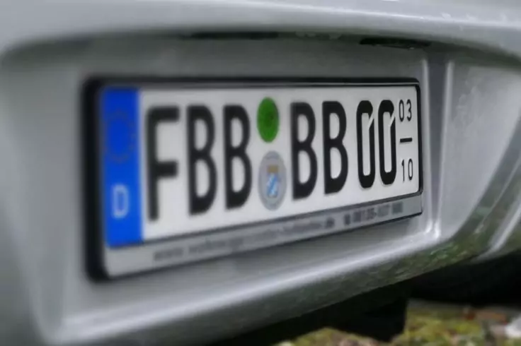 Nahaufnahme eines hinteren Nummernschilds an einem Auto mit blauem EU-Streifen und dem Länderkennzeichen 'D'
