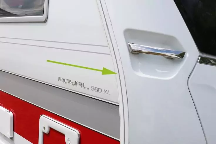 Weiße Seitenwand mit silbernem Griff, rotem Streifen unten, kleinem Klappfach mit weißem Rahmen, grünem Pfeilaufkleber, der auf den Schriftzug 'ROYAL 560 XL' zeigt