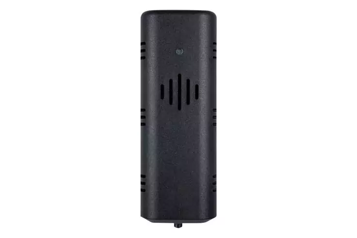 Schwarzes rechteckiges Kunststoffgehäuse, vertikal vor weißem Hintergrund; mittig fünf schräg angeordnete Lüftungsschlitze, seitlich jeweils drei horizontale Schlitze, kleiner runder Zapfen an der Unterkante