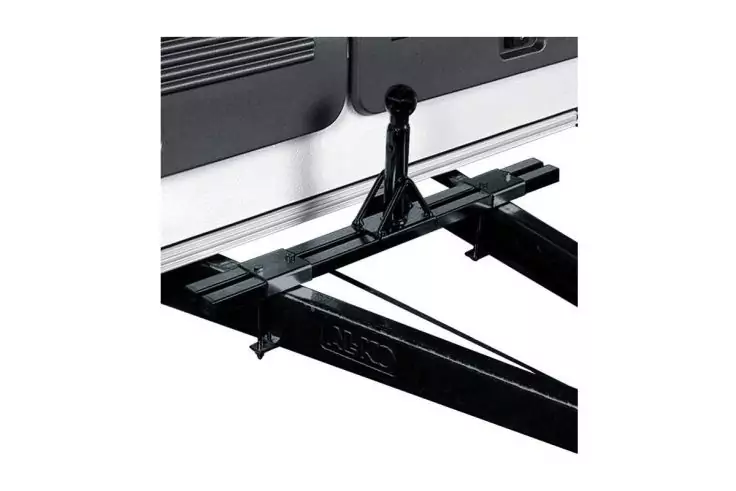 Schwarzes Metall-Anhängerteil mit Kugelkopf, befestigt am weißen Fahrzeugheck