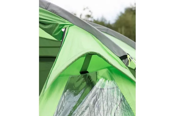 Teil einer grünen Zeltfront mit Vordach und durchsichtigem Kunststofffenster, unscharfe Bäume im Hintergrund