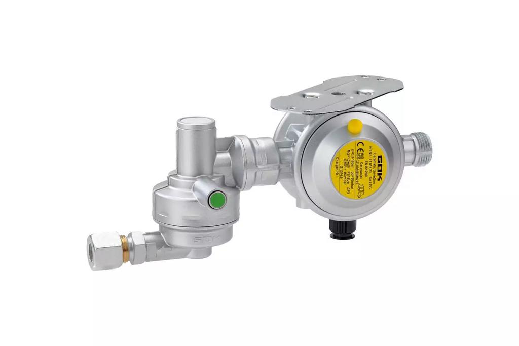 Silbernes Metallger&auml;t mit rundem Geh&auml;use, mehreren Rohranschl&uuml;ssen, gelbem runden Aufkleber mit schwarzer Schrift, gr&uuml;nem Punkt und schwarzem Anschluss, wei&szlig;er Hintergrund