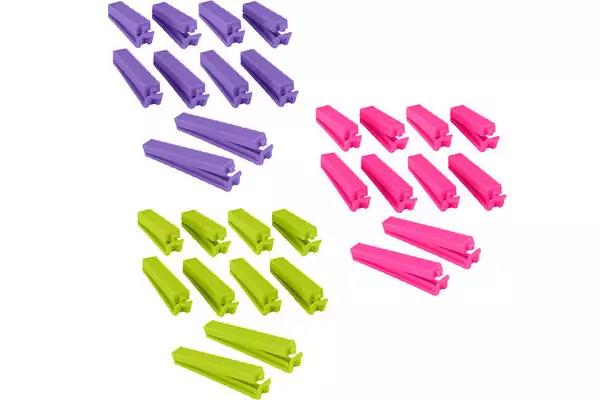 Mehrere kleine Hefter in drei Farben (lila, pink, hellgr&uuml;n) in Reihen auf wei&szlig;em Hintergrund