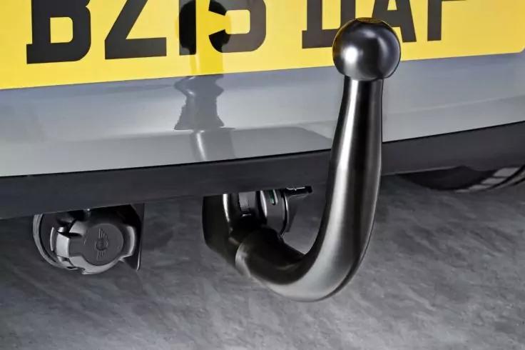 Heck eines Fahrzeugs mit Anh&auml;ngerkupplungshaken, Steckdose und gelbem Nummernschild