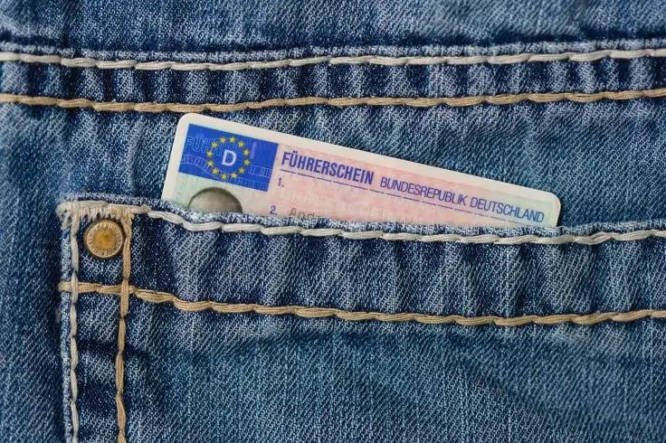 Teilweise sichtbarer blauer F&uuml;hrerschein mit Aufschrift 'F&Uuml;HRERSCHEIN BUNDESREPUBLIK DEUTSCHLAND' und EU-Symbol 'D' in Jeans-Tasche