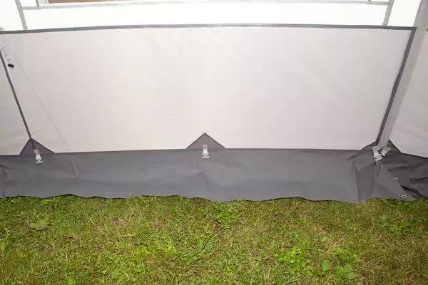 Innenseite einer Zeltwand mit hellgrauer Innenwand, grauer Bodenplane mit drei kleinen stoffdreiecken mit Druckkn&ouml;pfen und gr&uuml;nem Rasen unten