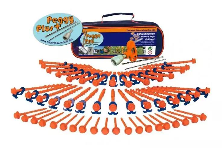 Mehrere orangefarbene Kunststoffteile mit runden Enden und blauen Clips in Reihen vor einer orange-blauen Tragetasche mit Griff und Produktaufkleber; ein orangefarbenes Objekt liegt daneben