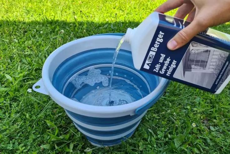 Reiniger wird mit Wasser in Eimer gemischt