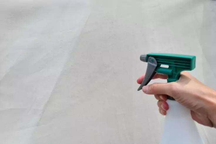 Zelthaut wird mit Imprägniermittel angesprüht