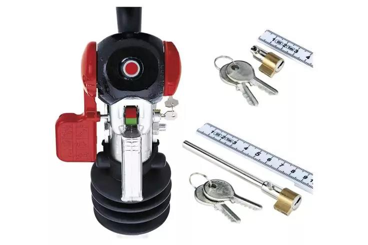Schwarzes und rotes Objekt mit schwarzem Faltenbalg, verchromten Metallteilen und rundem roten Knopf; daneben zwei Schlüssel mit Messingzylindern und zwei kurzen Metalllinealen auf weißem Hintergrund