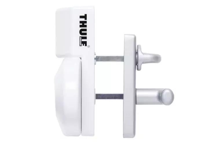 Weißes Kunststoffteil mit schwarzem 'THULE'-Schriftzug neben einer rechteckigen Metallplatte mit zwei zylindrischen Metallstiften