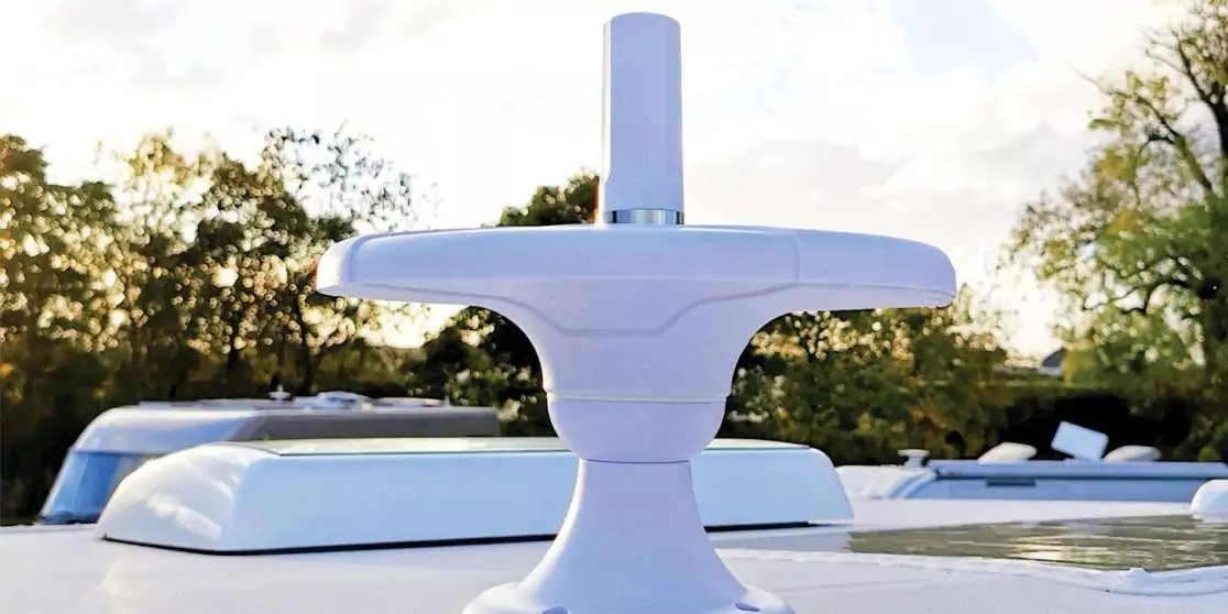 Wei&szlig;es T-f&ouml;rmiges Ger&auml;t auf dem Bootsdach, weitere wei&szlig;e Aufbauten, B&auml;ume und Himmel im Hintergrund