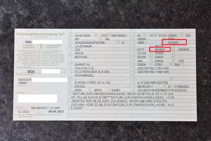 Nahaufnahme eines zweigeteilten hellen Formulars auf dunklem Untergrund. Linke Spalte mit Textbl&ouml;cken und ausgef&uuml;llten Feldern, rechte Spalte mit Tabellen, gedruckten Zahlen und Codes