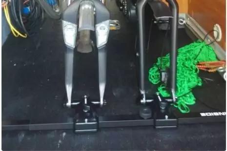 Zwei Motorradgabeln in schwarzen Halterungen auf einem schwarzen Ladeboden, rechts ein aufgerolltes gr&uuml;nes Seil