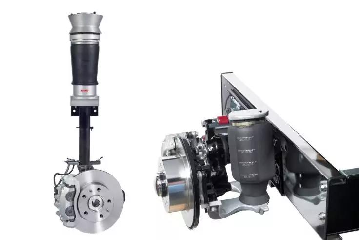 Zwei Fahrzeugaufh&auml;ngungen mit Bremsscheiben, Bremss&auml;tteln und Sto&szlig;d&auml;mpfern vor wei&szlig;em Hintergrund