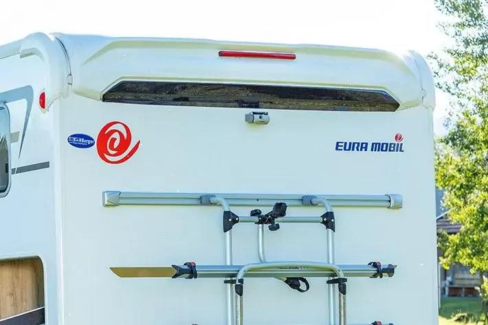 Heckansicht eines weißen Wohnmobils mit montiertem Fahrradträger, der Schriftzug "EURA MOBIL" und ein rotes Emblem