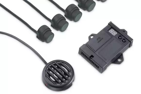 Rechteckiges schwarzes Elektronikmodul mit kleinem Digitaldisplay und Anschlussöffnungen, fünf runde schwarze Sensoren an Kabeln und ein rundes schwarzes, gittergedecktes Bauteil an einem Kabel