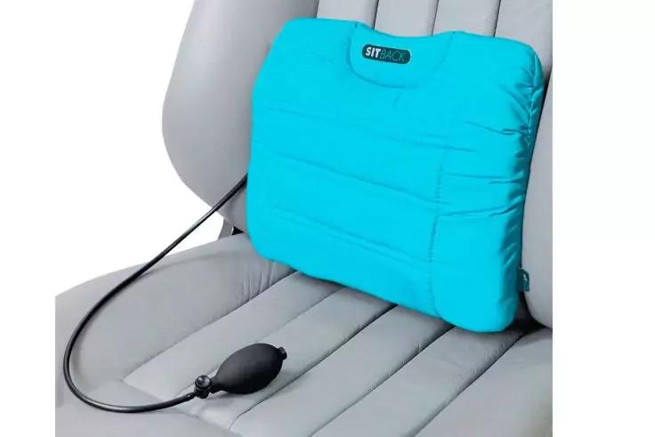 T&uuml;rkisfarbenes aufblasbares Kissen mit schwarzem Pumpball und Schlauch auf einem hellgrauen Autositz