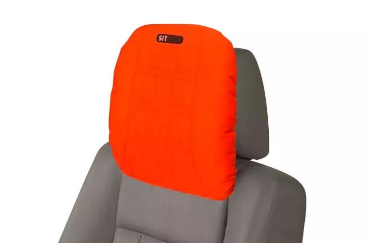 Leuchtend orangefarbener &Uuml;berzug auf der Kopfst&uuml;tze eines grauen Autositzes, mit kleinem schwarzem rechteckigem Etikett oben