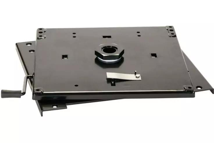 Schwarze quadratische Metallplatte mit rundem mittigem Ansatz, Hebel an einer Seite, mehrere rechteckige Aussparungen und Befestigungsbohrungen