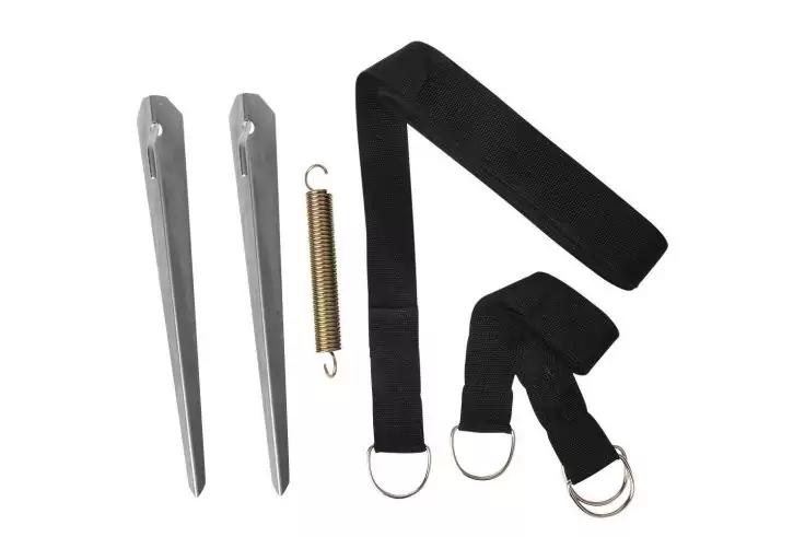 Zwei lange Metallpflöcke, eine Metallfeder und zwei schwarze Stoffriemen mit Metall-D-Ringen auf weißem Hintergrund