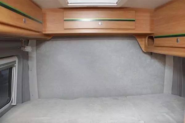 Hellgraue flache Oberfl&auml;che unter h&ouml;lzernen Oberschr&auml;nken mit gr&uuml;nem Streifen, Dachluke oben und seitliche Fenster mit grauen Vorh&auml;ngen