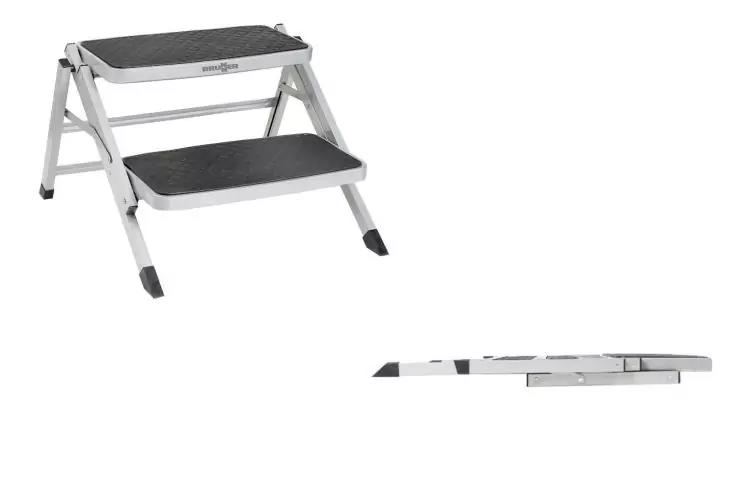 Aufgeklappter zweistufiger Tritt mit silbernem Metallgestell und schwarzen Trittplatten; daneben derselbe Tritt zusammengeklappt auf weißem Hintergrund