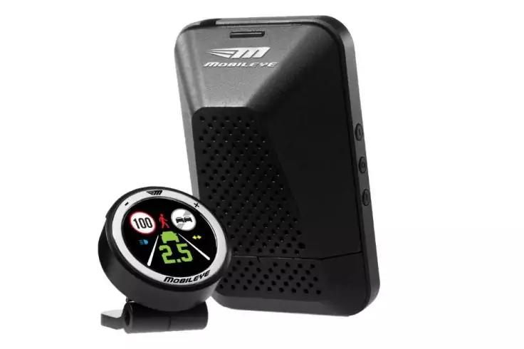 Schwarzes, rechteckiges Ger&auml;t mit gelochener Fl&auml;che; daneben rundes digitales Display auf St&auml;nder, zeigt 2.5 in Gr&uuml;n, wei&szlig;e 100 in rotem Kreis und kleine Symbole