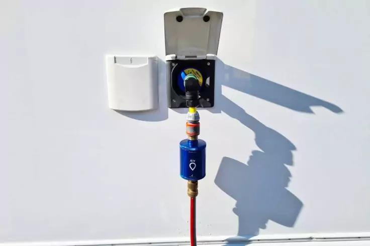 Ge&ouml;ffneter wei&szlig;er Kasten an wei&szlig;er Wand, darunter rotes Kabel mit blauem Zwischenst&uuml;ck und Schatten