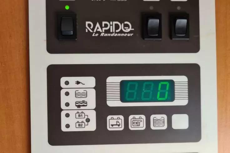 Grau-wei&szlig;es Bedienfeld mit drei schwarzen Kippschaltern oben, gr&uuml;ner Kontrollleuchte, Schriftzug "RAPIDO le Randonneur", darunter rechteckiges Display mit gr&uuml;nen Ziffern "888" und mehreren kleinen quadratischen Symbolen und Piktogrammen
