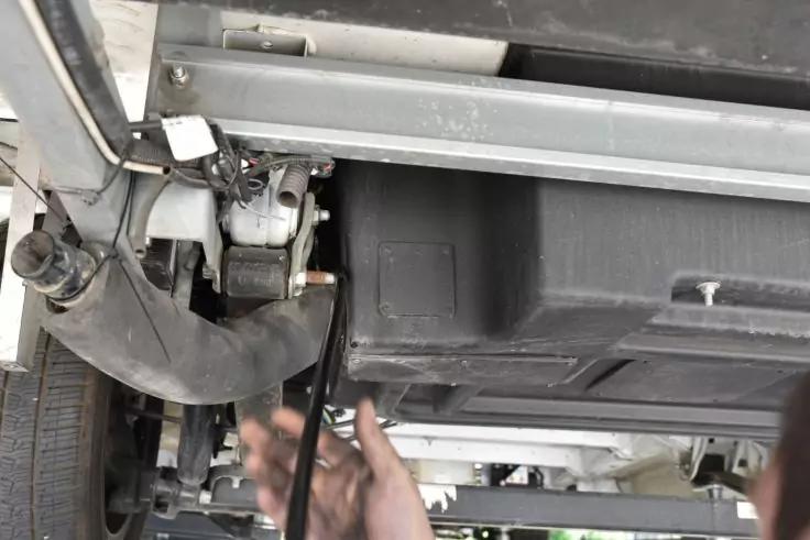 Metallrahmen, schwarzer Kunststoffkasten, Reifen, Kabel und zwei H&auml;nde, die ein Kabel halten