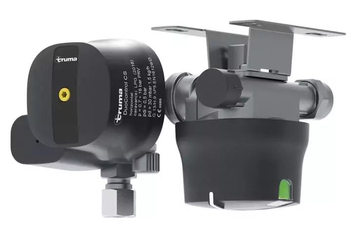 Zwei graue und schwarze zylindrische Metallgeräte mit Montageplatten, eines zeigt einen gelben Punkt und trägt den Schriftzug 'truma'