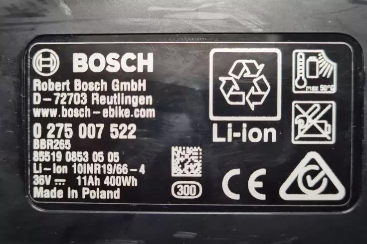 Schwarzes Etikett mit weißer Aufschrift: BOSCH-Logo, Text 'Li-ion', Recycling-Symbole, CE-Zeichen, QR-Code und Textzeilen mit 'Robert Bosch GmbH', 'D-72703 Reutlingen', '0 275 007 522', '36V 11Ah 400Wh', 'Made in Poland'