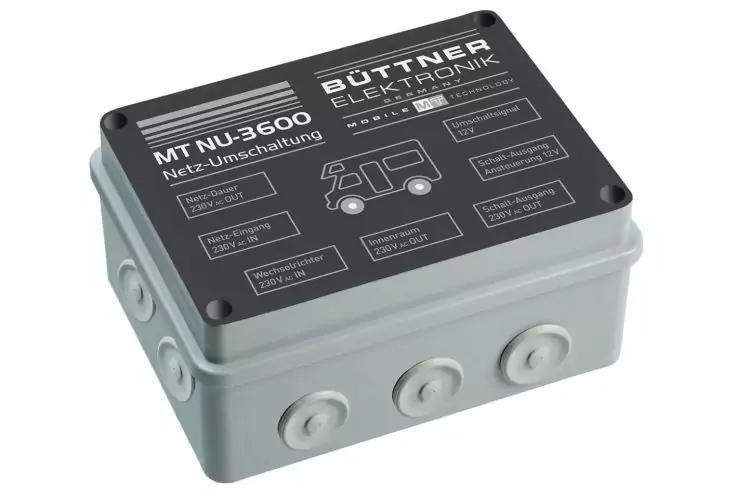 Boîtier rectangulaire en plastique gris avec couvercle noir, inscription blanche 'BÜTTNER ELEKTRONIK' et 'MT NU-3500', plusieurs pictogrammes blancs et trois entrées de câble rondes à l'avant