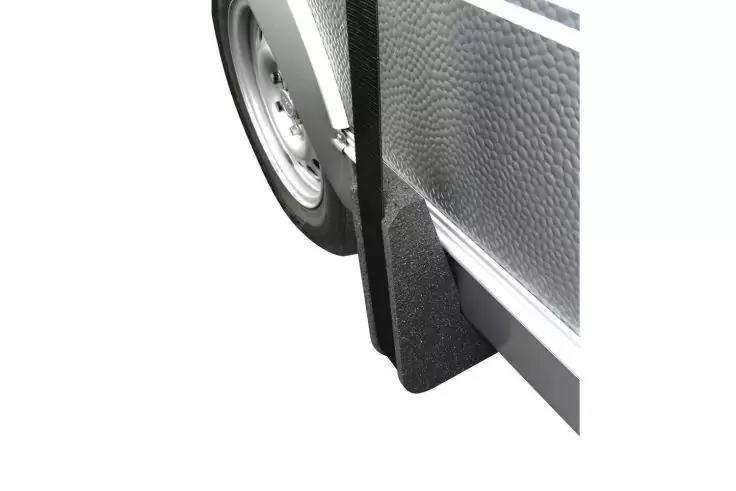 Nahaufnahme eines Reifens mit Felge, eines schwarzen Schmutzfangs und einer silbernen, strukturierten Seitenverkleidung