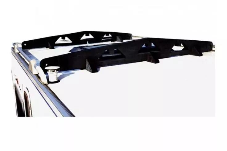 Weißes Fahrzeugdach mit schwarzem Dachträger aus zwei Querträgern und sichtbaren Metallbefestigungen