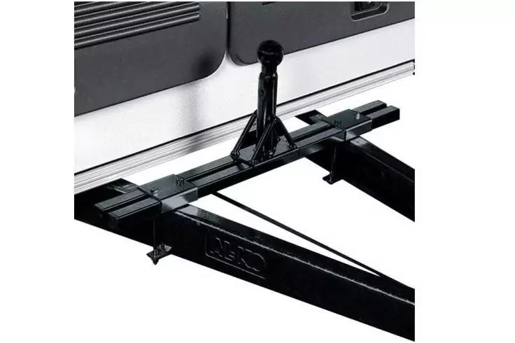 Schwarze Metall-Anhängerdeichsel mit Querstange und senkrechtem Stützkopf vor weißer Wand