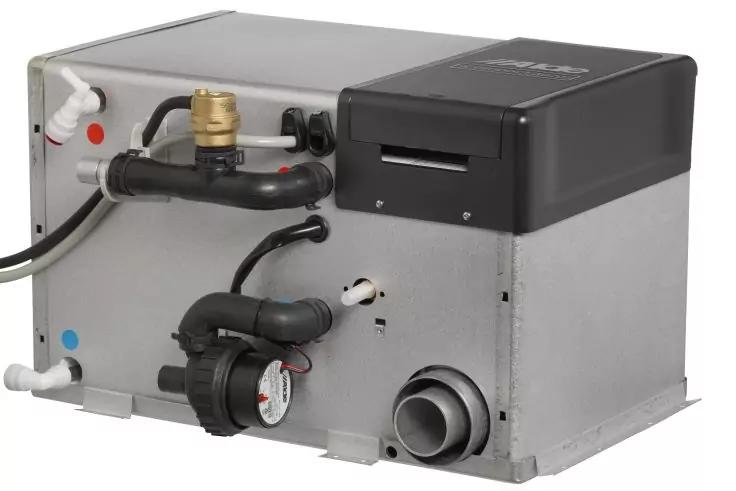 Rechteckiges Metallgerät mit schwarzen und weißen Rohren und Schläuchen, einem runden, zifferblattähnlichen Bauteil und einem großen runden Kunststoffanschluss