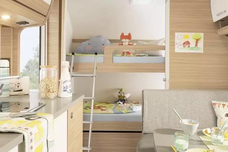 Zweistöckige Betten mit Leiter, Stofftiere, Küchenarbeitsplatte mit Gläsern und Gläsern, Tisch mit Schalen und Tassen, Fenster, Zeichnung an der Wand