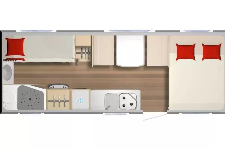 Draufsicht auf Innenraum mit Doppelbett rechts und zwei roten Kissen, Sitzbereich links mit rotem Kissen, Küchenzeile in der Mitte mit Spüle und Herd, Schränke und Badezimmer mit Toilette und Dusche links unten, Holzfußboden
