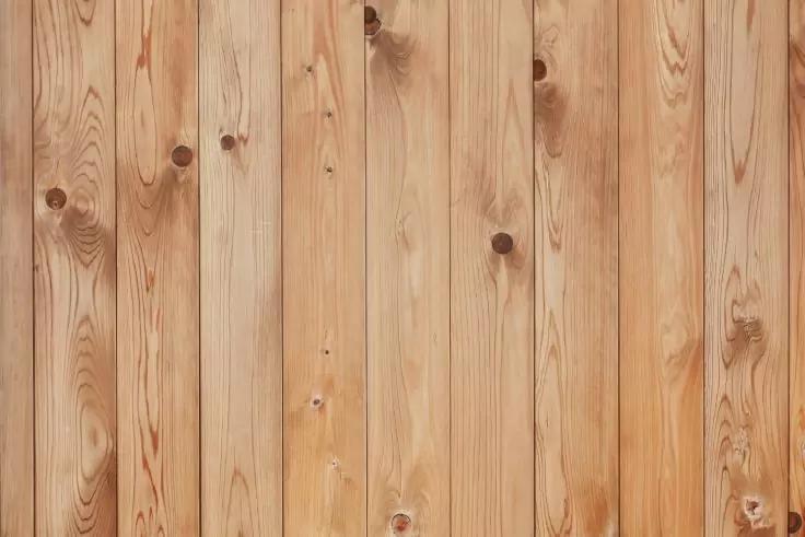 Helle, senkrecht angeordnete Holzbretter mit sichtbaren Aststellen und Holzmaserung