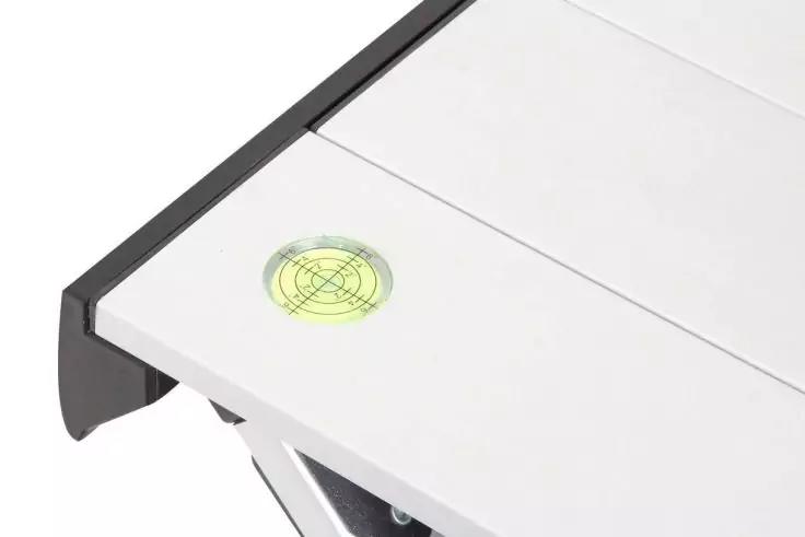 Weißes Paneel mit schwarzer Kante, gelb-grüne runde Libelle mit Kreuzlinien und teilweise sichtbare silberne Metallhalterung