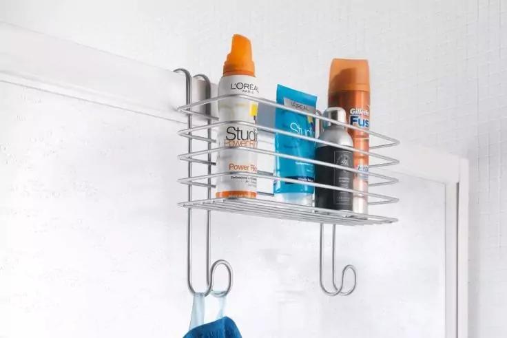 Metall-Drahtkorb an T&uuml;r mit drei Flaschen und einer Tube; darunter zwei Haken, an einem h&auml;ngt ein blaues Handtuch