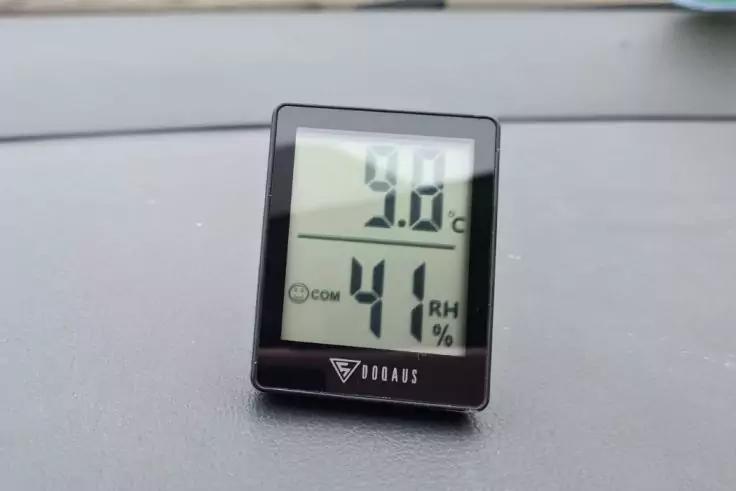 Kleines schwarzes digitales Ger&auml;t auf Armaturenbrett, Display zeigt oben "9.0&deg;C" und unten "41 RH %"
