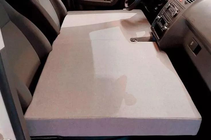 Große Schaumstoffplatte liegt flach über den Vordersitzen und der Mittelkonsole eines Autos