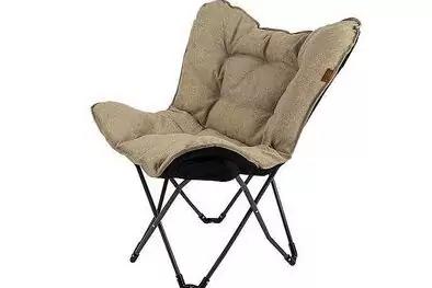 Beiger, gepolsterter Sessel mit gesteppter Oberfl&auml;che und schwarzem X-f&ouml;rmigem Metallgestell auf wei&szlig;em Hintergrund