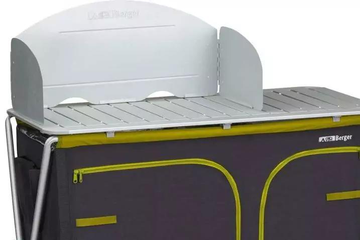 Hellgraue Metall-Arbeitsfl&auml;che mit erh&ouml;htem R&uuml;ckteil und seitlichen Klappen; darunter ein dunkelgrauer Stoffschrank mit gelbgr&uuml;nen Rei&szlig;verschl&uuml;ssen