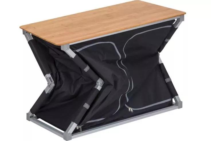 Tisch mit rechteckiger Holzplatte, X-f&ouml;rmigem silbernem Metallgestell und schwarzer Stoffh&uuml;lle mit sichtbaren N&auml;hten und Rei&szlig;verschluss